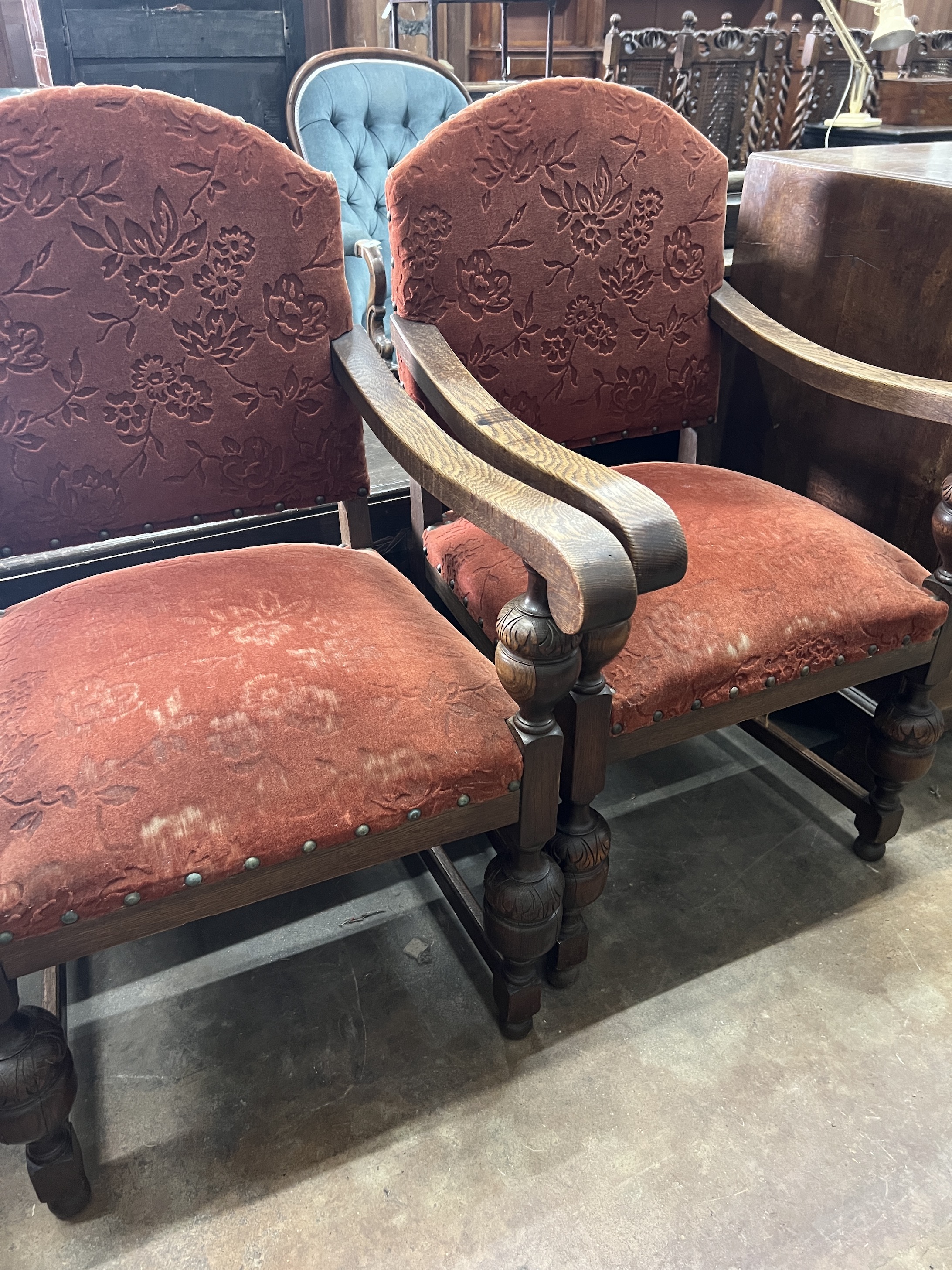 A pair of 1920's Jacobean revival oak elbow chairs, width 60cm, depth 65cm, height 103cm